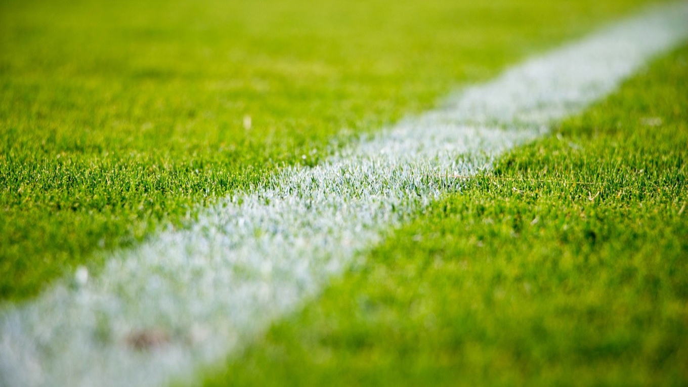 Foto: Sandro Schuh, https://unsplash.com/de/fotos/nahaufnahme-einer-weissen-linie-auf-grunem-rasen-auf-einem-fussballfeld-HgwY_YQ1m0w