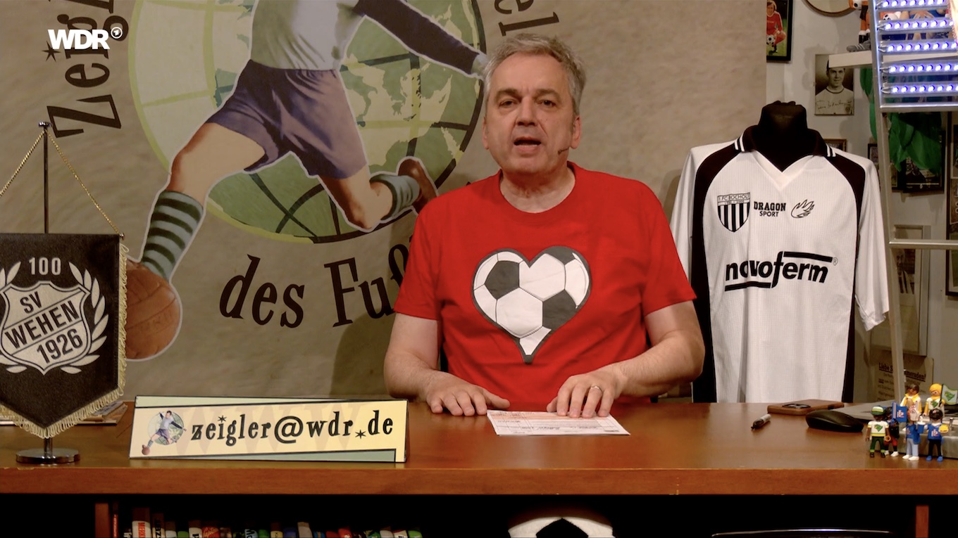 Screenshot aus "Zeiglers wunderbare Welt des Fußballs", https://www.ardmediathek.de/video/zeiglers-wunderbare-welt-des-fussballs/aufstiegsfeierei/wdr/Y3JpZDovL3dkci5kZS9CZWl0cmFnLXNvcGhvcmEtYzRiZDY3NGQtNjcxZi00MmY2LTkyYzYtZTJkM2Y1MTljOTFk